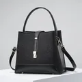 Detail of black lace and leather handbag with gold clasp on a minimalist stand - 23x12x21 / Black