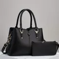 Detail view of black lychee grain leather handbag set with gold hardware and shoulder strap - Black