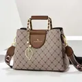 Detail van vintage bedrukte tas met gouden blad hanger en verfijnd logo - Beige Splitsen (Stijl 3)