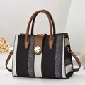 Detail of tricolor woven texture handbag with brown leather trim and golden metal clasp - Black