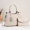 Detail view of cream crossbody handbag with matching wallet and metal leaf charm - Off White