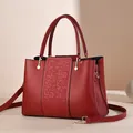 Elegante rode leren handtas met borduursel en afneembare goudkleurige schouderriem - Wijnrood