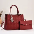 Detalle de bolso burdeos con diseño acolchado, colgante de hoja y un pequeño bolso extra - Rojo