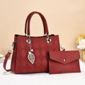 Detail der roten gesteppten Tragetasche mit Silberblatt-Anhänger und Briefumschlagtasche - Rot