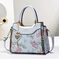 Detailed shot of light blue floral embroidery handbag with elegant gold hardware and pearls - Blue