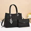 Detail der schwarzen Handtasche aus Kieselleder mit Steppmuster und Blattanhänger - Schwarz