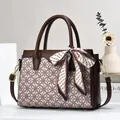 Dettaglio borsa vintage con sciarpa di seta decorativa e manici in pelle marrone - Medio / Cachi