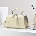 Detail of cream leather shoulder bag with logo, top handle and patterned jacquard strap - White