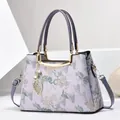 Lilac floral jacquard handbag with golden metal frame and detachable shoulder strap - Light Purple