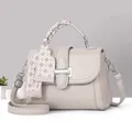 Chic light gray pebbled leather handbag with a silk scarf handle and a metal buckle closure - Gray