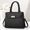 Vue détaillée d'un sac à main noir grainé avec fermoir doré et rivets de protection - 28cm x 11cm x 22cm / Noir