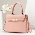 Detail of light pink litchi grain tote bag featuring gold clasp and premium hardware - 28cm x 11cm x 22cm / Pink
