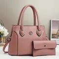 Détail du sac à main rose poudré grainé et de son portefeuille assorti en cuir - Rose