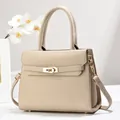 Détail du sac beige texture litchi avec fermoir tournant doré et fleur d'orchidée - 28cm x 11cm x 22cm / Khaki