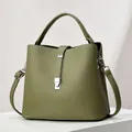 Olive green bucket bag in pebble leather with silver hardware on a display stand - Length 23 Width 12 Height 21 / Green