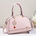 Borsa a tracolla rosa in ecopelle grana litchi con ciondolo a quadrifoglio dorato - Rosa