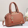 Borsa a conchiglia marrone in pelle martellata con ciondoli quadrifoglio e finiture oro - Giallo Terra