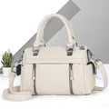 Détails du cuir grainé crème et des fermetures éclair en métal foncé sur le sac à main - Blanc Cassé