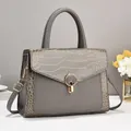 Elegant grey faux leather handbag with crocodile pattern and golden metal lock detail - Gray