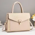 Detailed close-up of beige leather handbag featuring croc-embossed texture and golden buckle - Khaki