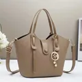 Dettaglio della borsa a secchiello kaki con trama litchi e ciondolo stella-luna - 28cmx9cmx18cm / Cachi