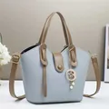 Dettaglio borsa a secchiello blu-grigio con trama a grana e pendente a stella di perla - 28cmx9cmx18cm / Blu