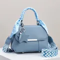 Detail der blauen Lederhandtasche mit Polka-Dot-Schalgriff und Stern-Anhänger - Blau