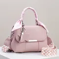 Detailansicht einer rosa Handtasche mit Sternanhänger und gemustertem breitem Gurt - Rosa