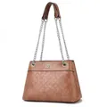 Detail of brown shoulder bag featuring embossed floral patterns and chain strap - Pink