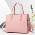 Dettaglio borsa tote rosa con goffratura a righe verticali e finiture metalliche dorate - Rosa