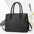 Dettaglio ravvicinato di una borsa tote nera con strisce verticali e manici di qualità - Nero