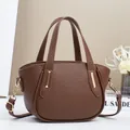 Brown litchi grain leather crossbody bag with top handle and gold hardware detail - Coffee