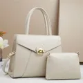 Dettaglio del set di borse in pelle martellata color crema con chiusura circolare dorata - Bianco Sporco