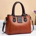 Detail view of the brown leather tote bag with silver hardware and adjustable shoulder strap - Yellow