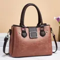 Detail view of the vintage brown crossbody bag with dual handles and silver square buckles - Pink