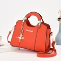 Sac à main élégant en cuir orange vif avec pendentif étoile et détails dorés brillants - Rouge