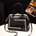 Classic black patent leather handbag with gold bow clasp and pearl accent trim - Black