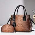 Detail of brown crocodile pattern tote bag set with golden hardware and black handles - L29xW14xH23cm / Earthy Yellow
