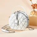 White quilted circular shoulder bag with silver chain strap and top handle design - White