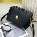 Minimalistische zwarte crossbody tas van leer met drie ritsen en gouden hardware - Zwart