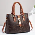 Deep brown women's tote bag with monogram print and golden hardware in studio setting - Earthy Yellow With Lettering