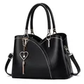 Borsa nera con cuciture bianche a contrasto e ciondolo a cuore dorato con frange - Nero