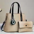 Detailed view of beige crocodile pattern tote bag with luxury charm and black strap - Beige