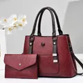 Detail of burgundy PU leather tote set with cylindrical handles and metal buckle accents - Burgundy