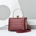 Macro view of burgundy patent leather evening bag with golden rivets and diamond clasp - One Size / Burgundy