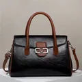 Détail du cabas en cuir grainé noir avec boucle en métal argenté et bandoulière marron - Noir