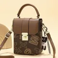 Minimalist square crossbody phone bag in dark brown leather with golden twist lock and charm - Coffee