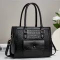 Dettaglio borsa a mano nera con trama a coccodrillo ed eleganti accessori in metallo oro - Nero