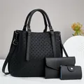 Dettaglio del set di borse in pelle nera con trama intrecciata e finiture in metallo - Tote Portafoglio E Porta Carte / Nero