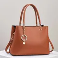 Chic brown lychee texture leather handbag with gold smiley pendant and dual handles - Khaki/Earth Yellow